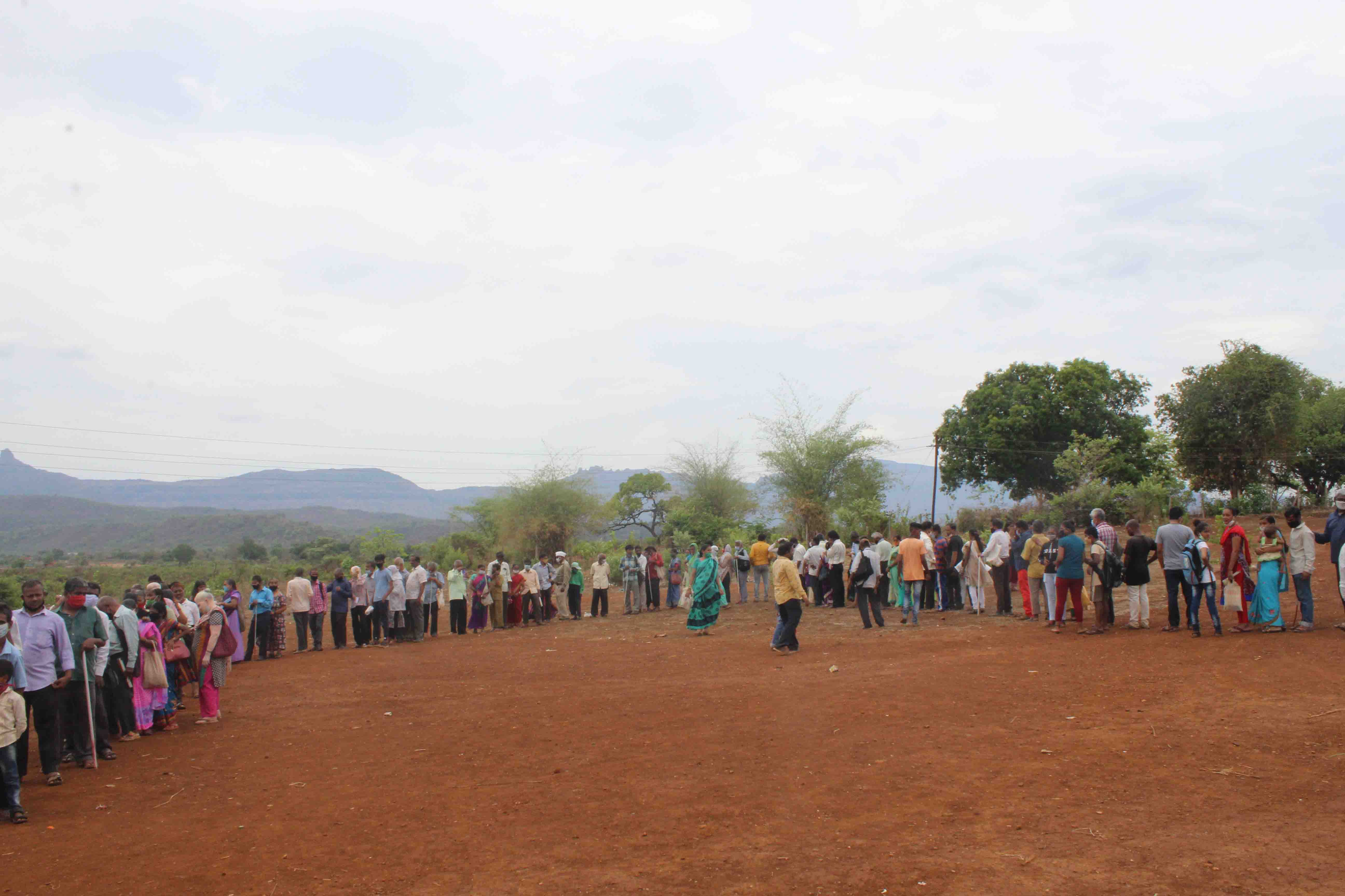 Beneficiaries Standing in Que in Open Ground to Collect Their Essential Items KIT